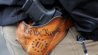 An attendee at a gun rights rally open carries his gun in a holster that reads "We the People" from the Preamble to the United States Constitution