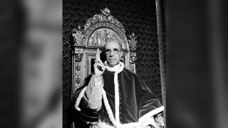 FILE – Pope Pius XII, wearing the ring of St. Peter, raises his right hand in a papal blessing at the Vatican, in Sept. 1945.