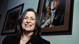 Marilynn "Lynn" Malerba stands next to a photograph of late Chief Ralph Sturges at Tribal offices