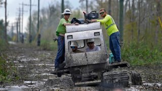 Electrical workers ride through marsh in a marsh buggy to restore power lines in the aftermath of Hurricane Ida in Houma, La., Friday, Sept. 17, 2021. The Louisiana terrain presents special challenges like just getting out to some of the areas where power poles and lines need to be fixed. In some areas lines thread through thick swamps that can only be accessed by air boat or specialized equipment like a marsh buggy. Linemen don waders to climb into chest-high muddy waters also home to alligators and water moccasins.