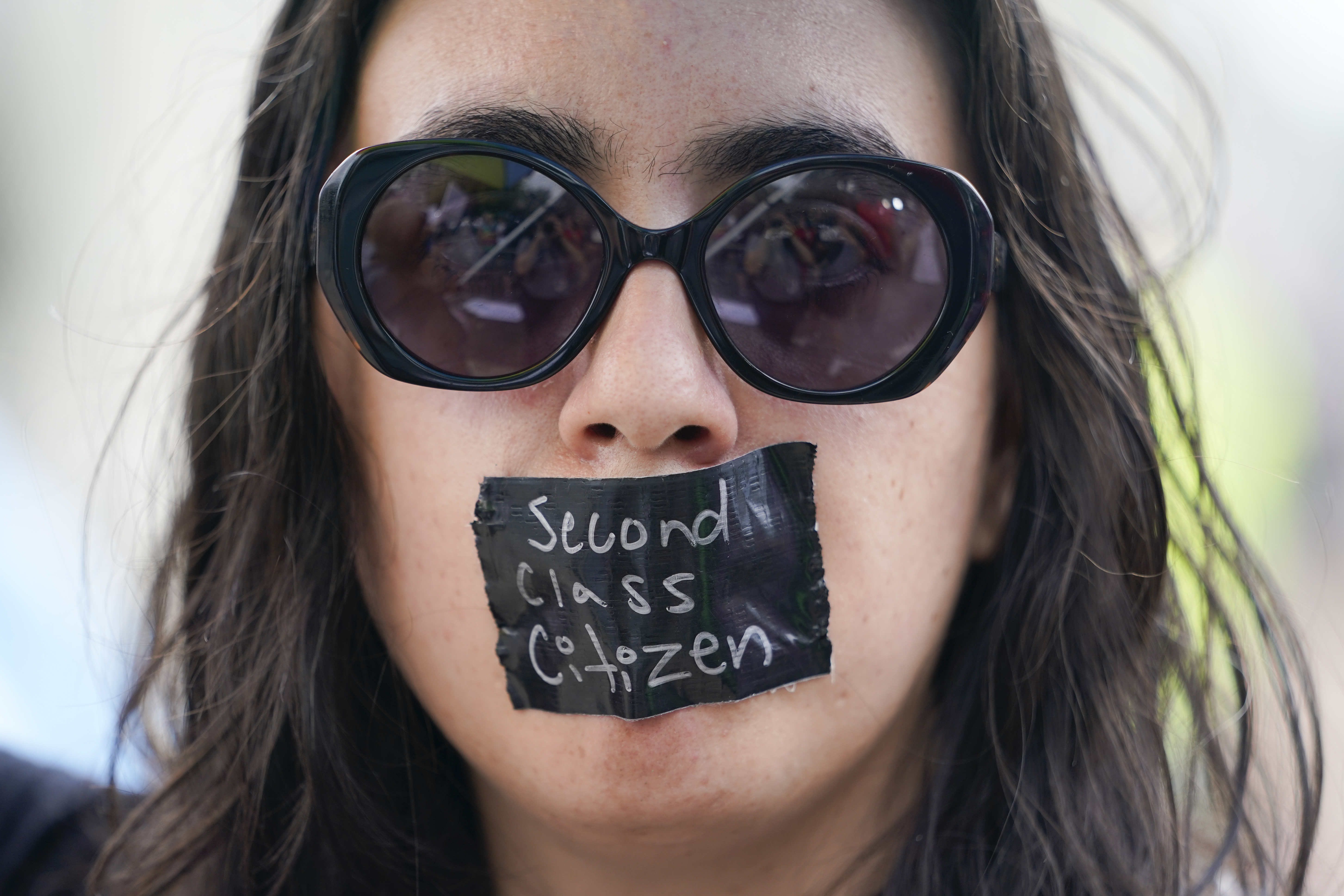 An abortion-rights activist wears tape reading “second class citizen” on their mouth as they protest outside the Supreme Court in Washington, Friday, June 24, 2022.