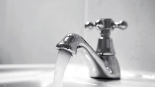 Close up of chrome tap, water running.