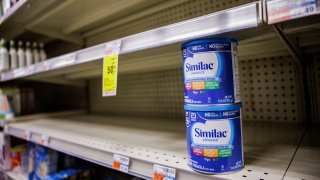 FILE - Shelves normally meant for baby formula sit nearly empty at a store in downtown Washington, DC, on May 22, 2022.