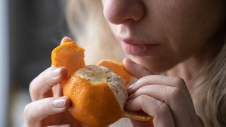 Woman smelling an orange.