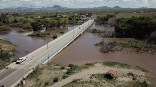 People drive over a bridge in Duncan, Ariz., following a flooding.