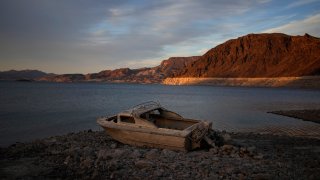 FILE - A formerly sunken boat sits high and dry along the shoreline of Lake Mead