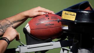 Football loaded into jugs machine during the NFL training camp