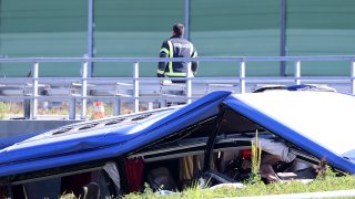 A rescuer stands next wreckage of a bus at the crash scene in Podvorec, near Zagreb, Croatia