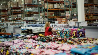 An employee folds clothes for sale at a Costco Wholesale Corp. warehouse in Brooklyn, New York, U.S., on Wednesday, July 25, 2012. The U.S. Bureau of Economic Analysis is scheduled to release personal consumption data on July 27 Photographer: Victor J. Blue/Bloomberg via Getty Images