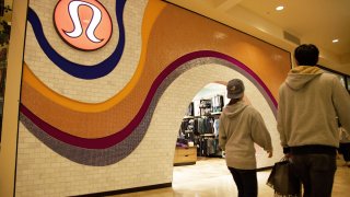 Pedestrians pass by a Lululemon store.