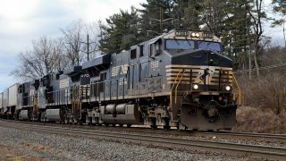 A Norfolk Southern freight train pulled by Locomotive 7565, a GE ES44DC Evolution Series diesel locomotive.