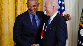 FILE - President Joe Biden and former President Barack Obama shake hands and stand together on stage