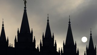 The angel Moroni statue atop the Salt Lake Temple is silhouetted against a cloud-covered sky, at Temple Square in Salt Lake City on Feb. 6, 2013.