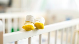 Baby booties on the edge of a cot