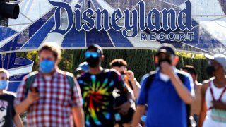 People leave the Disneyland Resort on Disneyland Park and Disney California Adventure’s reopening day amidst the coronavirus disease (COVID-19) outbreak, in Anaheim, California, April 30, 2021.