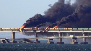Black smoke billows from a fire on the Kerch bridge that links Crimea to Russia, after a truck exploded, near Kerch, on October 8, 2022.