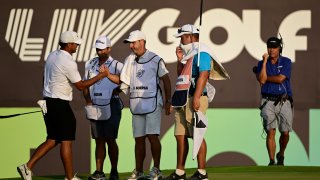 Team Captain Brooks Koepka of Smash GC and caddie Ricky Elliott shake hands on the 18th green during day three of the LIV Golf Invitational – Jeddah at Royal Greens Golf & Country Club on October 16, 2022 in King Abdullah Economic City, Saudi Arabia.