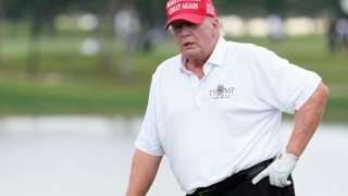 Former President Donald Trump stands on the 18th green during the Pro-Am tournament before the LIV Golf series at Trump National Doral, Oct. 27, 2022.