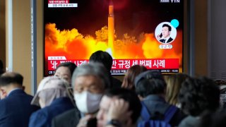 A TV screen shows a file image of North Korea's missile