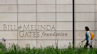 FILE - A person walks by the headquarters of the Bill and Melinda Gates Foundation on April 27, 2018,