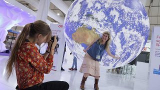 Conference participants photograph one another under a model of Planet Earth during the UNFCCC COP27 climate conference on Nov. 09, 2022 in Sharm El Sheikh, Egypt.
