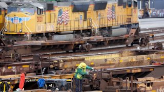 A rail employee works a Union Pacific Intermodal Terminal rail yard on November 21, 2022 in Los Angeles, California.