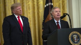 U.S. President Donald J. Trump, left, listens to Senator Lindsey Graham, a Republican from South Carolina, speaking during an event in the East Room of the White House in Washington, D.C., U.S., on Wednesday, Nov. 6, 2019. Trump celebrated Republicans’ record on confirming federal judges on Wednesday, saying his administration has done better than any other in terms of “quality and quantity” of judges appointed to the bench.