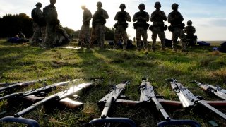 FILE - Weapons lie on the ground as Ukrainian personnel take a break