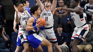 Xavier's Colby Jones is guarded by UConn's Jordan Hawkins, left, Alex Karaban, center, and Adama Sanogo, right, in the first half of an NCAA college basketball game, Jan. 25, 2023, in Storrs, Connecticut.