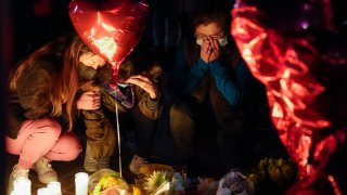 Women pause at a memorial at a vigil honoring the victims of a shooting at the Star Ballroom Dance Studio on Monday, Jan. 23, 2023, in Monterey Park, Calif.