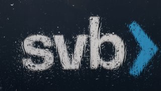 The Silicon Valley Bank (SVB) logo is seen through a rain-covered window.
