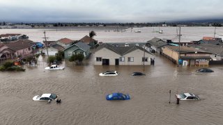 This aerial photograp shows cars and homes engulfed by floodwaters in Pajaro, California on Saturday, March 11, 2023.