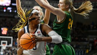 UConn's Aaliyah Edwards, left, is guarded by Vermont's Anna Olson, right, in the first half of a first-round college basketball game in the NCAA Tournament, Saturday, March 18, 2023, in Storrs, Conn.