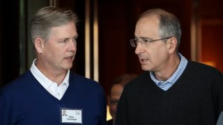 (L-R) Michael Cavanagh, then-chief financial officer of Comcast, talks with Brian Roberts, chief executive officer of Comcast, as they arrive for the annual Allen & Company Sun Valley Conference, July 9, 2019 in Sun Valley, Idaho.