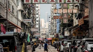 A man pushes a trolley across a street in the Kowloon district of Hong Kong on November 22, 2022.