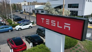 A sign marks the location of a Tesla dealership on April 19, 2023 in Schaumburg, Illinois.