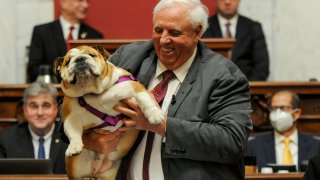 West Virginia Gov. Jim Justice holds up his dog Babydog as he comes to the end of his State of the State speech in the House chambers, at the West Virginia State Capitol in Charleston, W.Va., Thursday, Jan. 27, 2022.