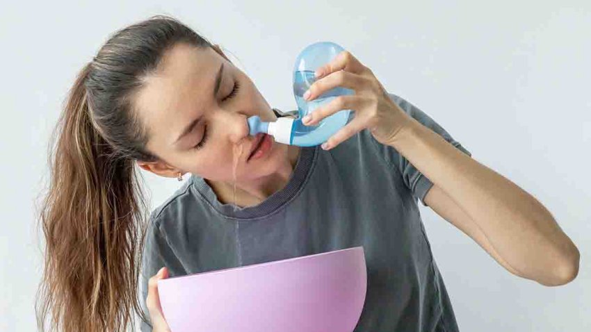 Nasal irrigation. A young girl uses the Neti Pot to treat her runny nose and colds. Nasal lavage, irrigation therapy.