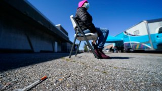 A syringe is seen on the ground as Lisa McFadden waits to be treated near a Baltimore City Health Department RV, Monday, March 20, 2023, in Baltimore. The Baltimore City Health Department’s harm reduction program uses the RV to address the opioid crisis, which includes expanding access to medication assisted treatment by deploying a team of medical staff to neighborhoods with high rates of substance abuse and offering buprenorphine prescriptions. (AP Photo/Julio Cortez)