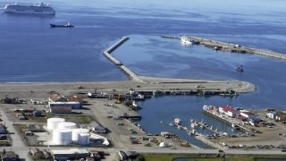 This Aug. 20, 2017, photo provided by the City of Nome is an aerial view of the Port of Nome, Alaska, with the luxury cruise ship Crystal Serenity anchored offshore because it was too big to dock at the port. Shipping lanes that were once clogged with ice for much of the year along Alaska’s western and northern coasts have relented thanks to global warming, and the nation’s first deep water Arctic port should be operational in Nome by the end of the decade. (Nome Port Director Joy Baker/City of Nome via AP)