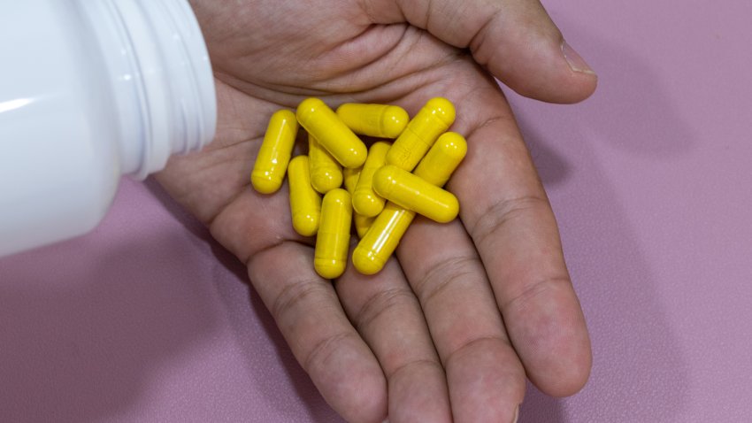 Hands holding yellow capsules, berberine.