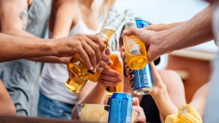 Group of people with beer and soda celebrating outdoors together