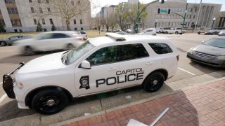 FILE – A Capitol Police SUV is parked across the street from the Hinds County Courthouse, left, and the main offices of the Jackson Police Department, right, in downtown Jackson, Miss., Feb. 13, 2023. On Wednesday, July 12, a federal judge dismissed a lawsuit filed by Latasha Smith, a Mississippi woman who says she was hit by a stray police bullet while lying in bed. Smith was in bed when an officer from the state-run Capitol Police fired several bullets at a suspect running through her Jackson apartment complex, according to her federal complaint. (AP Photo/Rogelio V. Solis, File)