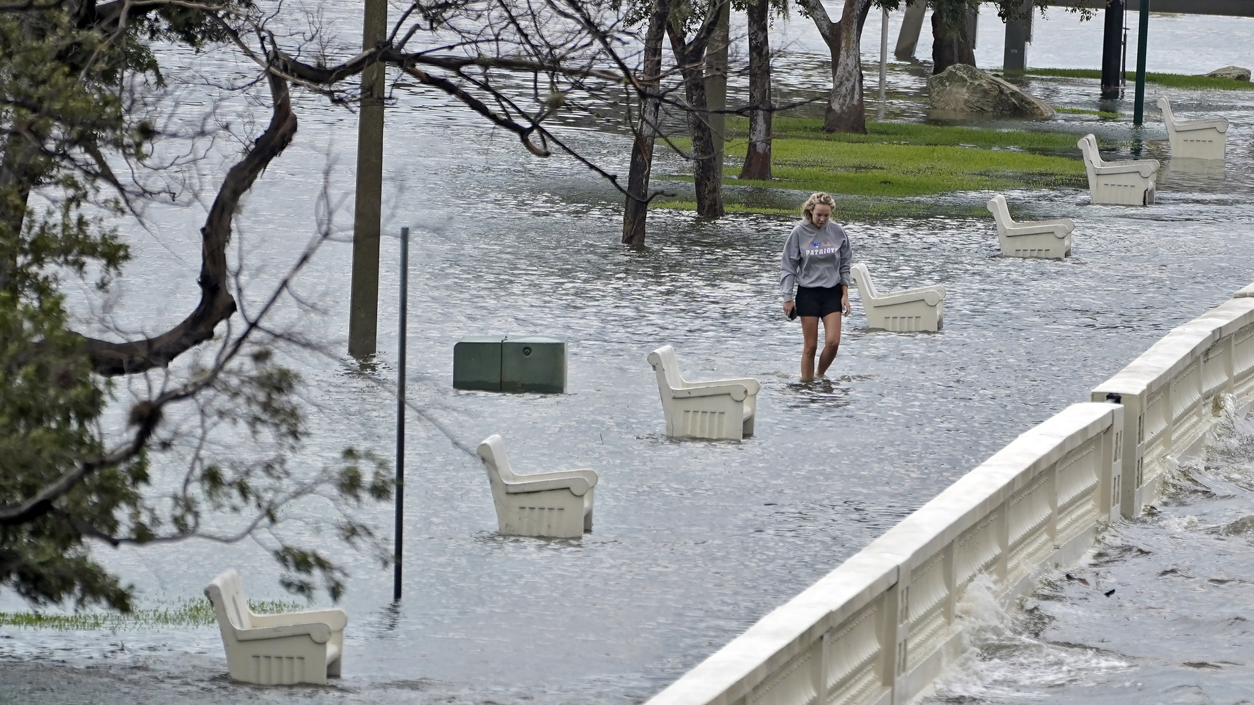 A woman walks through flooded water along Bayshore Blvd caused by storm surge from Hurricane Idalia, Aug. 30, 2023, in Tampa, Florida. Idalia made landfall earlier this morning along the Big Bend of the state.