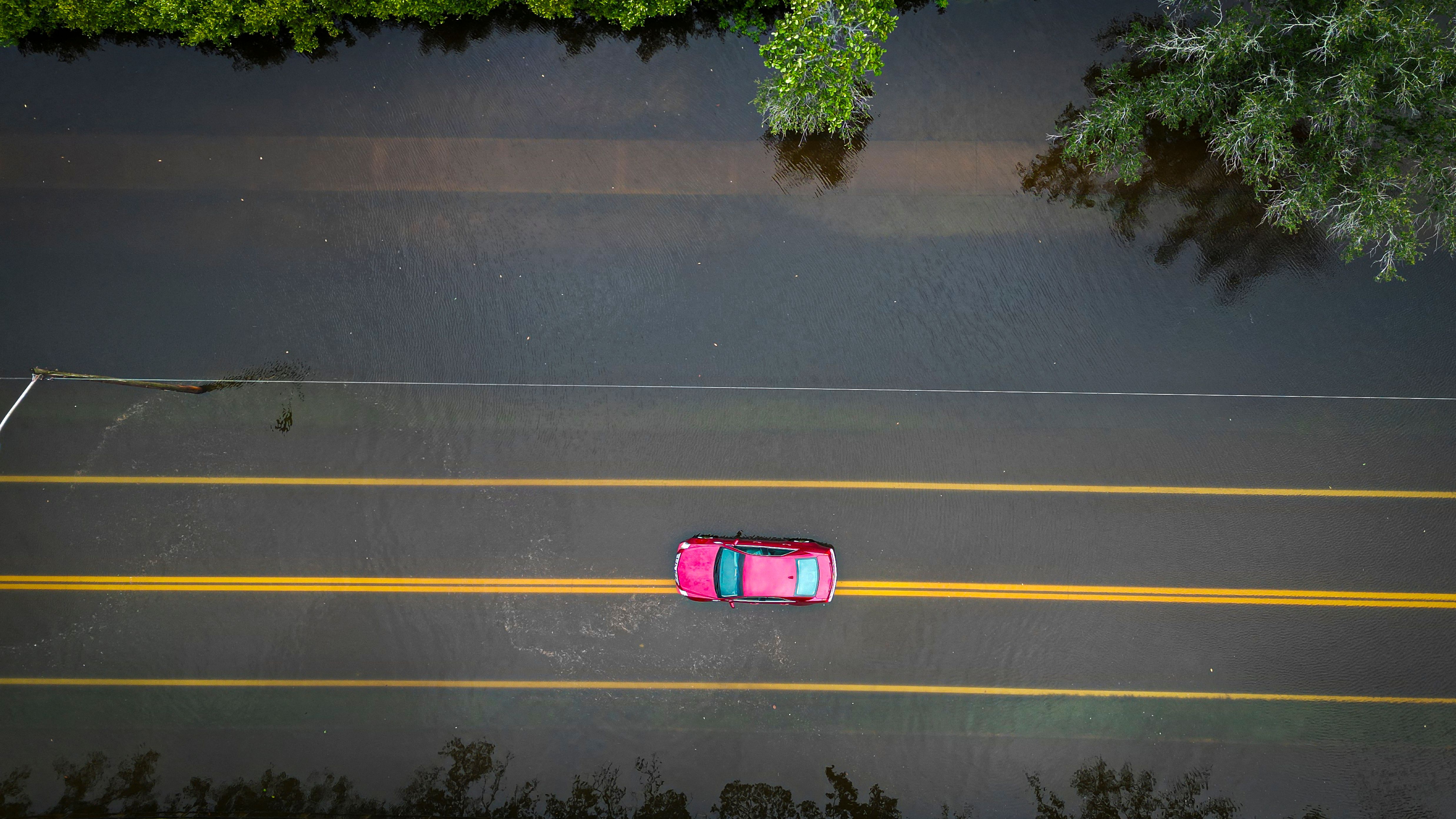 A car drives through a flooded street in Tampa, Florida, Aug. 30, 2023, after Hurricane Idalia made landfall.