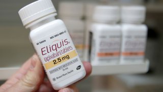 A pharmacist holds a bottle of the drug Eliquis, made by Pfizer Pharmaceuticals, at a pharmacy in Provo, Utah, January 9, 2020.