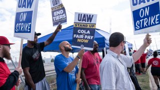 (L-R) Supporter Ryan Sullivan, and United Auto Workers members Chris Sanders-Stone, Casey Miner, Kennedy R. Barbee Sr. and Stephen Brown picket outside the Jeep Plant on September 18, 2023 in Toledo, Ohio.