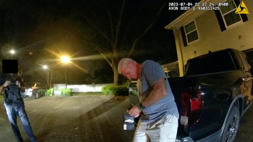 In this image from video provided by the Tampa Police Department, officers talk with Joseph Ruddy, a prosecutor with the U.S. Attorney’s Office in Tampa, outside his home in Temple Terrace, Fla., on the evening of July 4, 2023. A portion of the image is obscured by the source. Ruddy, whose blood-alcohol level tested at 0.17%, twice the legal limit, was charged with driving under the influence with property damage — a first-degree misdemeanor punishable by up to a year in prison. Despite his own admissions and witness testimony, he was not charged with leaving the scene of an accident.