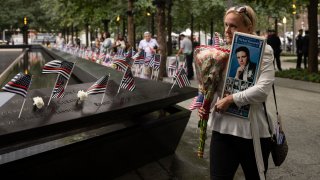 Diane Massaroli holds a picture of her late husband, Michael Massaroli, before the commemoration ceremony of the Sept. 11, 2001, terror attacks, Monday, Sept. 11, 2023, in New York.