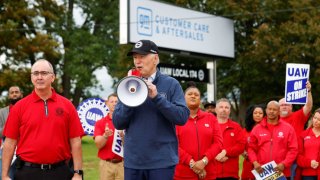 President Joe Biden speaks next to Shawn Fain, president of the United Auto Workers, as he joins striking members of the union on the picket line outside GM’s Willow Run Distribution Center in Bellville, Michigan, Sept. 26, 2023.